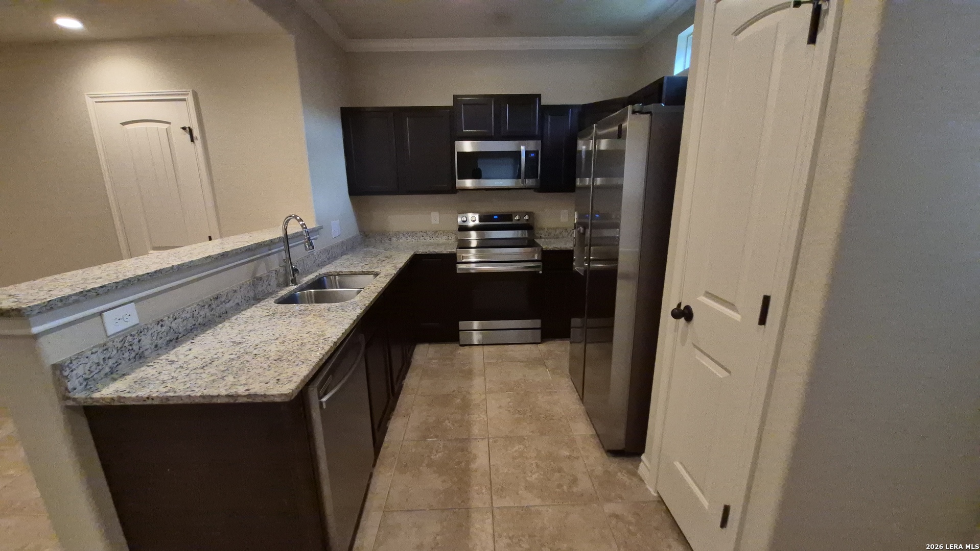6414 Luglio Lane, Unit 101 San Antonio, TX 78233 - Photo 7 of 23 a kitchen with granite countertop a refrigerator and a sink