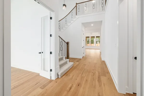 a view of a hallway with wooden floor and staircase