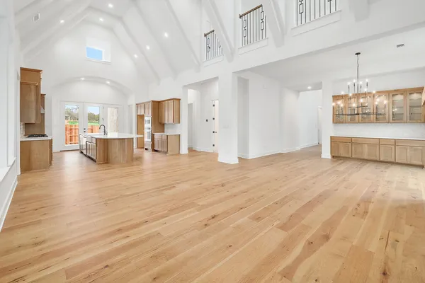 a view of a living room and kitchen with stainless steel appliances wooden floor