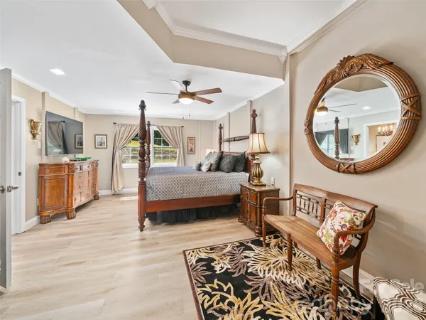 a spacious bedroom with a bed and a flat screen tv