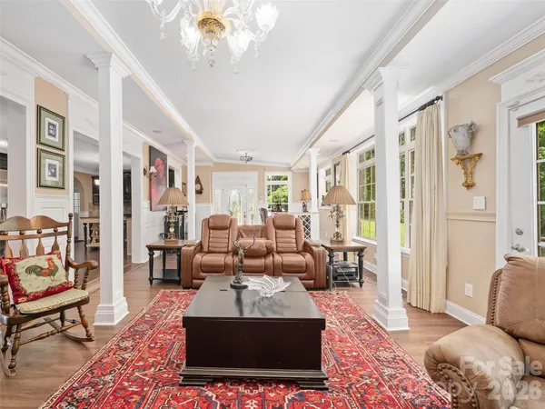 a living room with furniture a rug and a floor to ceiling window
