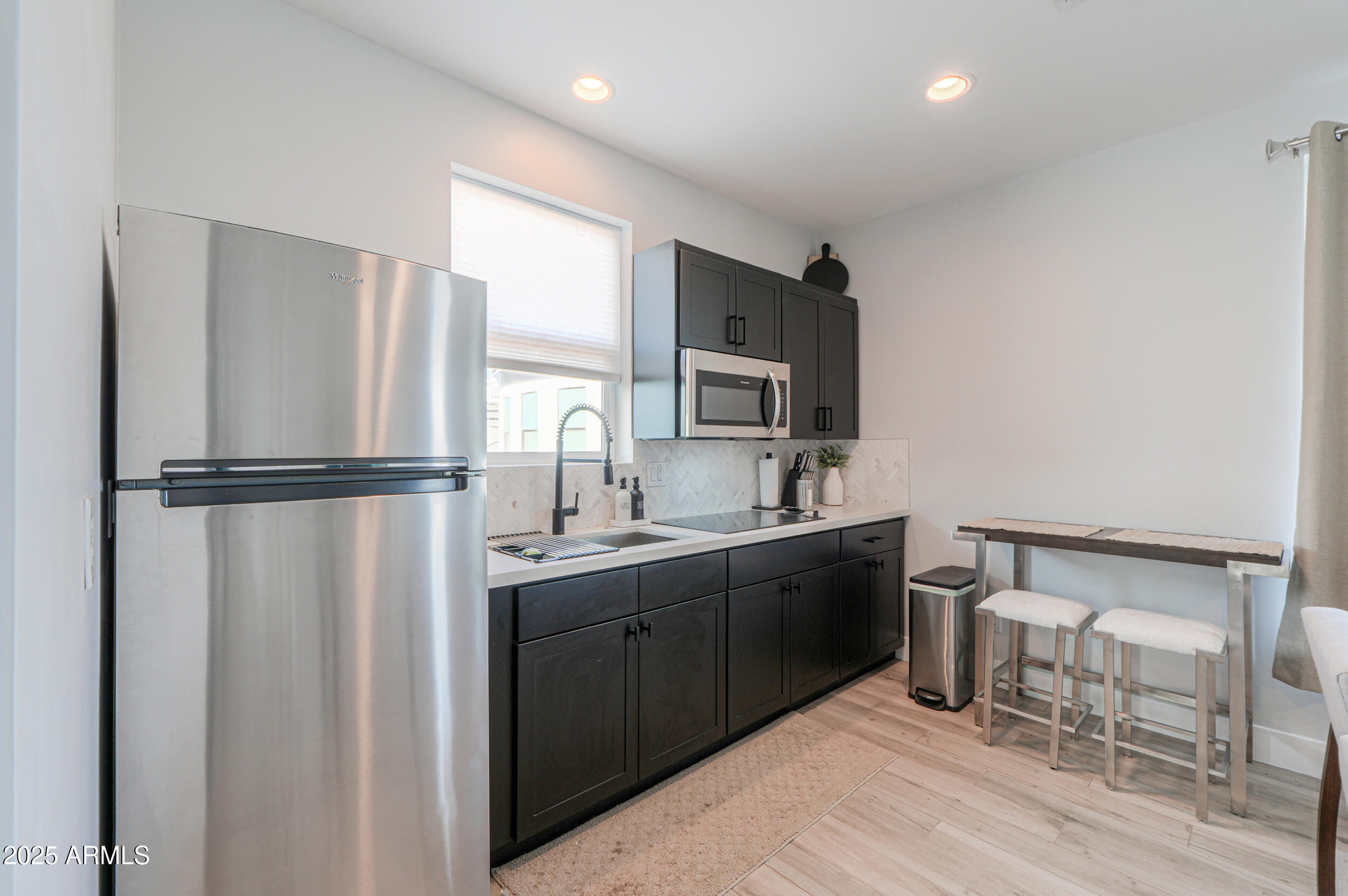 2529 West Magma Road San Tan Valley, AZ 85144 - Photo 70 of 93 a kitchen with stainless steel appliances granite countertop a refrigerator sink and white cabinets