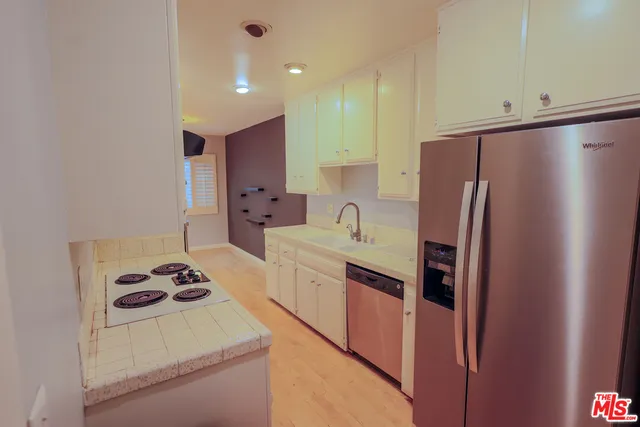a kitchen with granite countertop a refrigerator and a sink