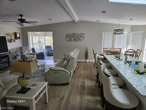 a living room with furniture and a wooden floor