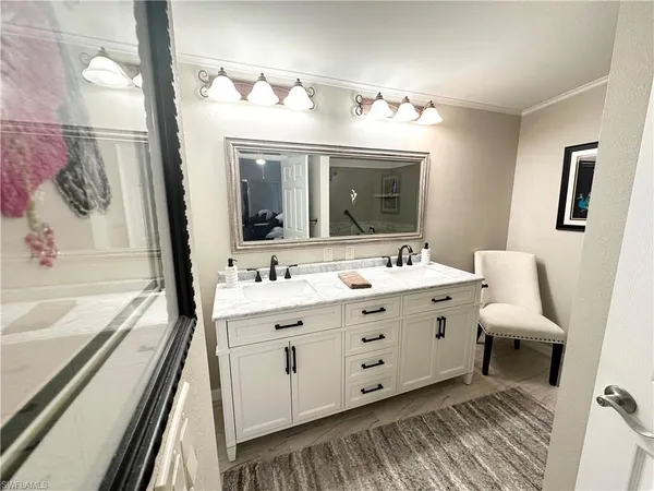 a bathroom with a double vanity sink a mirror and a shower