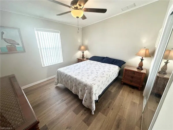 a bedroom with a bed wooden floor and window