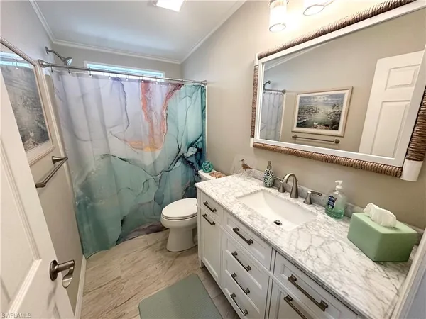 a bathroom with a granite countertop sink toilet and shower