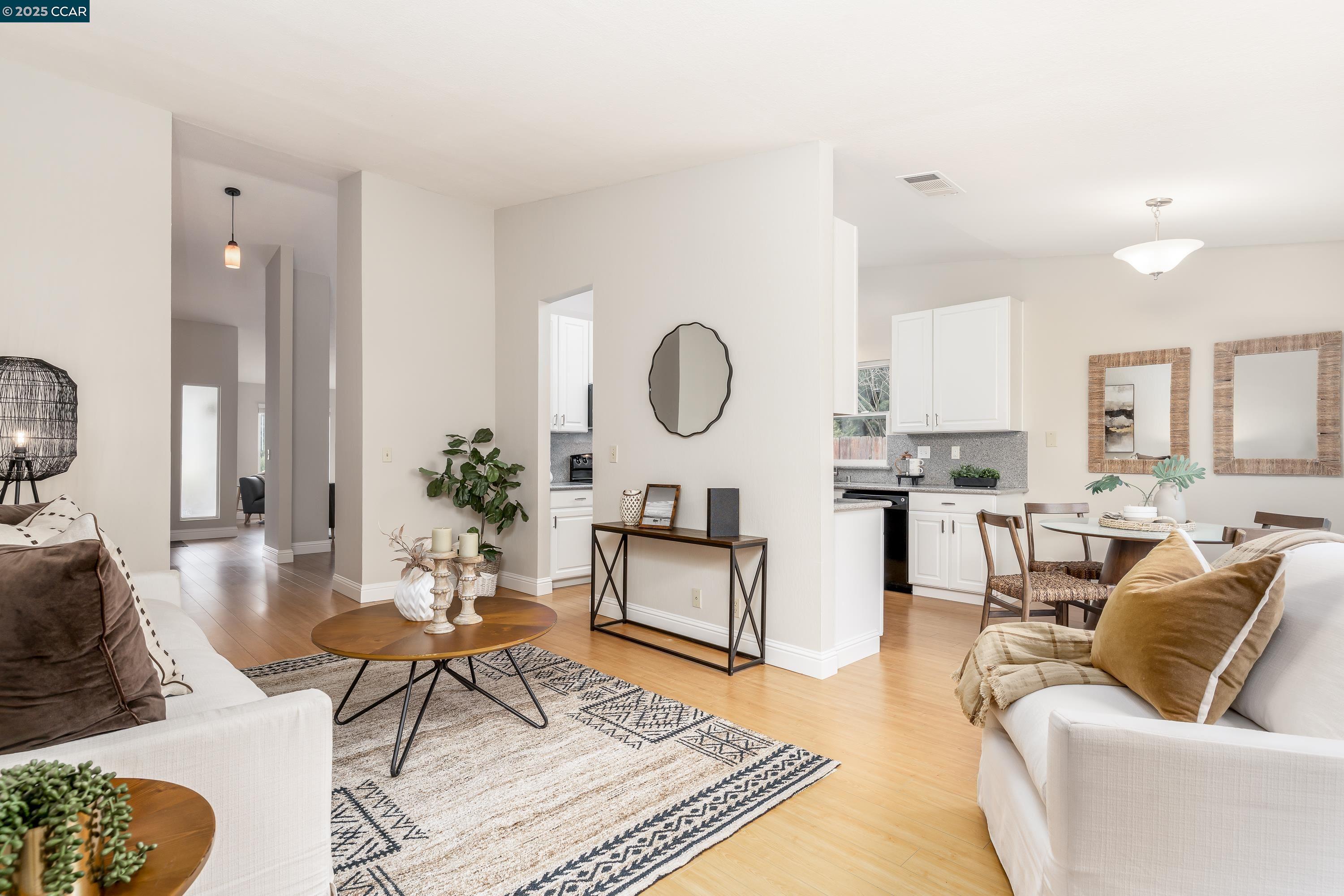 a living room with furniture a rug and a dining table