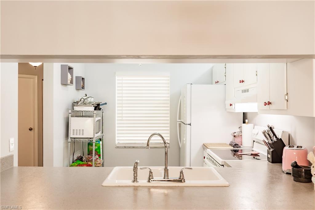 2750 Kings Lake Boulevard, Unit 204 Naples, FL 34112 - Photo 11 of 31 a kitchen with sink refrigerator and stove