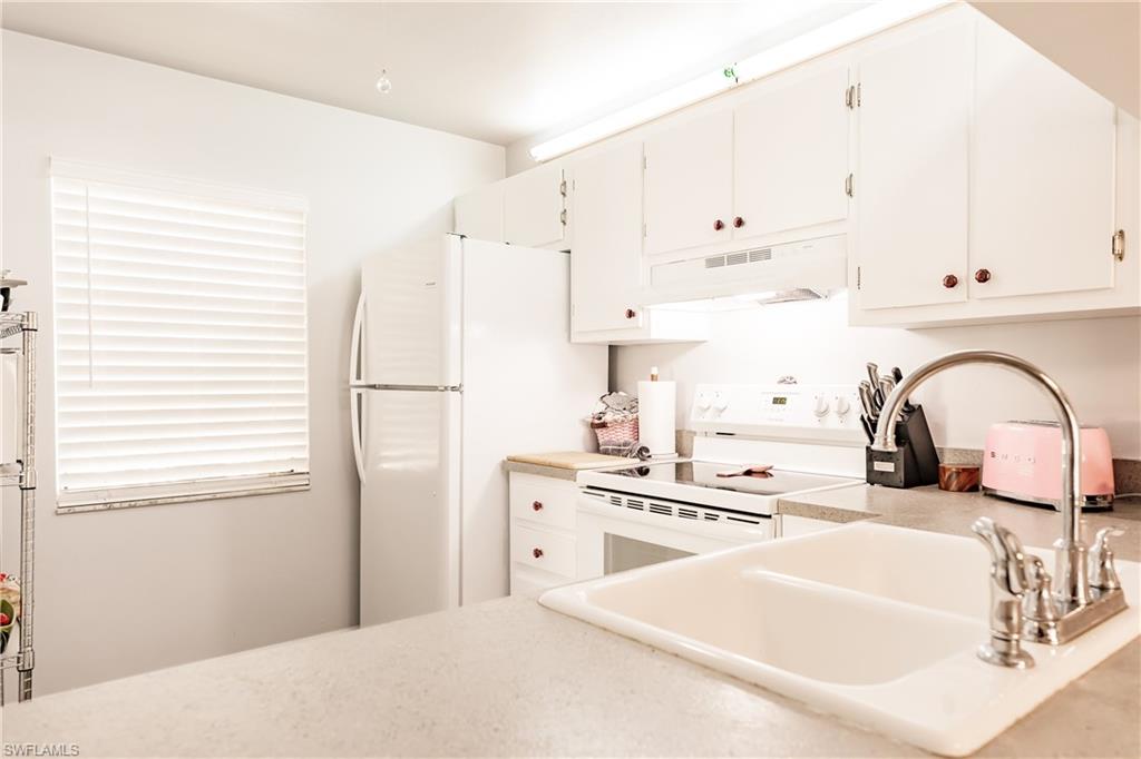2750 Kings Lake Boulevard, Unit 204 Naples, FL 34112 - Photo 12 of 31 a kitchen with stainless steel appliances granite countertop a sink a stove and refrigerator