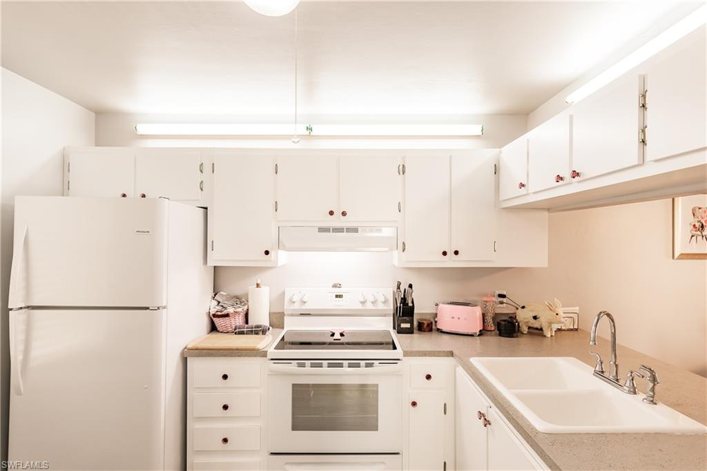 2750 Kings Lake Boulevard, Unit 204 Naples, FL 34112 - Photo 13 of 31 a kitchen with cabinets appliances and a sink