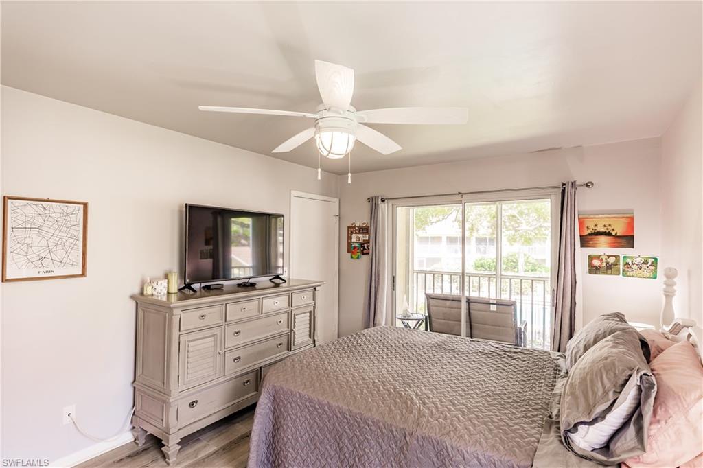 2750 Kings Lake Boulevard, Unit 204 Naples, FL 34112 - Photo 19 of 31 a bedroom with a bed and a flat screen tv