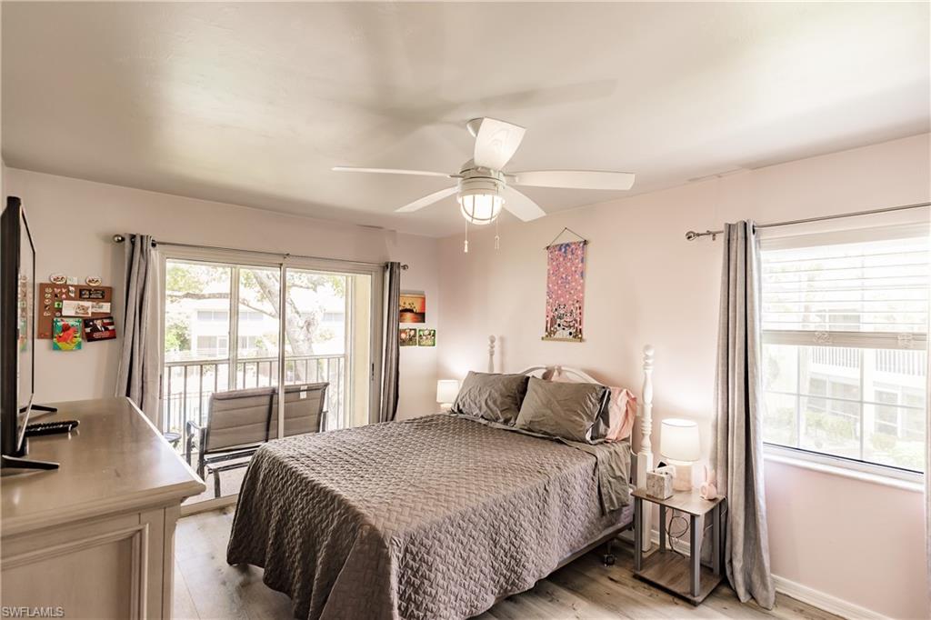 2750 Kings Lake Boulevard, Unit 204 Naples, FL 34112 - Photo 20 of 31 a bedroom with a large bed and a desk