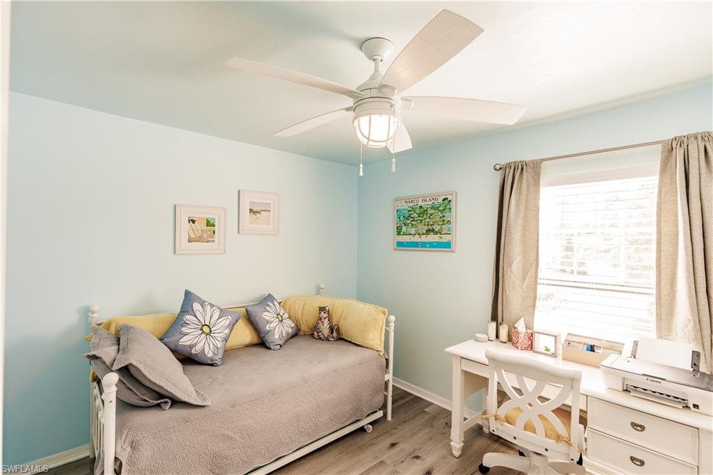 2750 Kings Lake Boulevard, Unit 204 Naples, FL 34112 - Photo 22 of 31 a bedroom with a bed and a chandelier