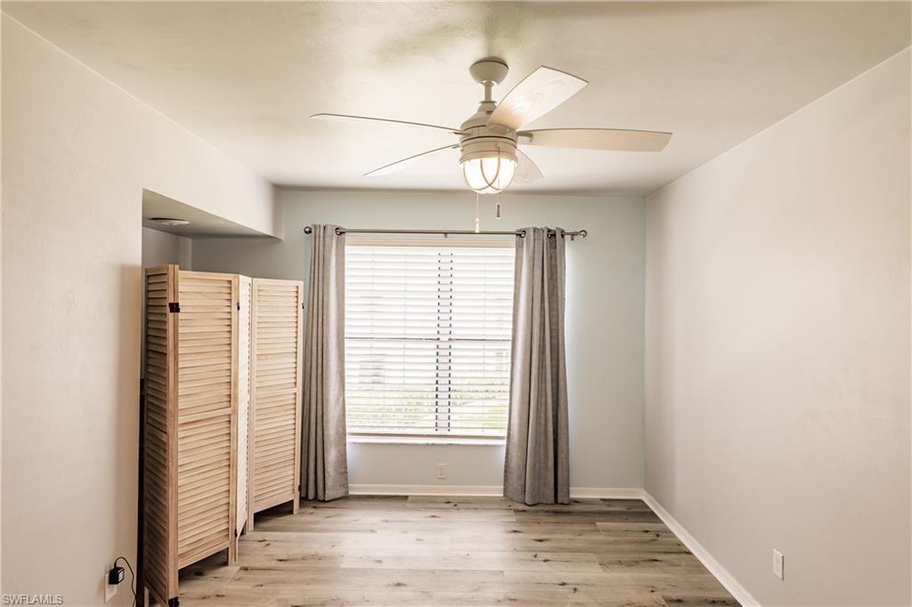 2750 Kings Lake Boulevard, Unit 204 Naples, FL 34112 - Photo 26 of 31 an empty room with wooden floor fan and windows