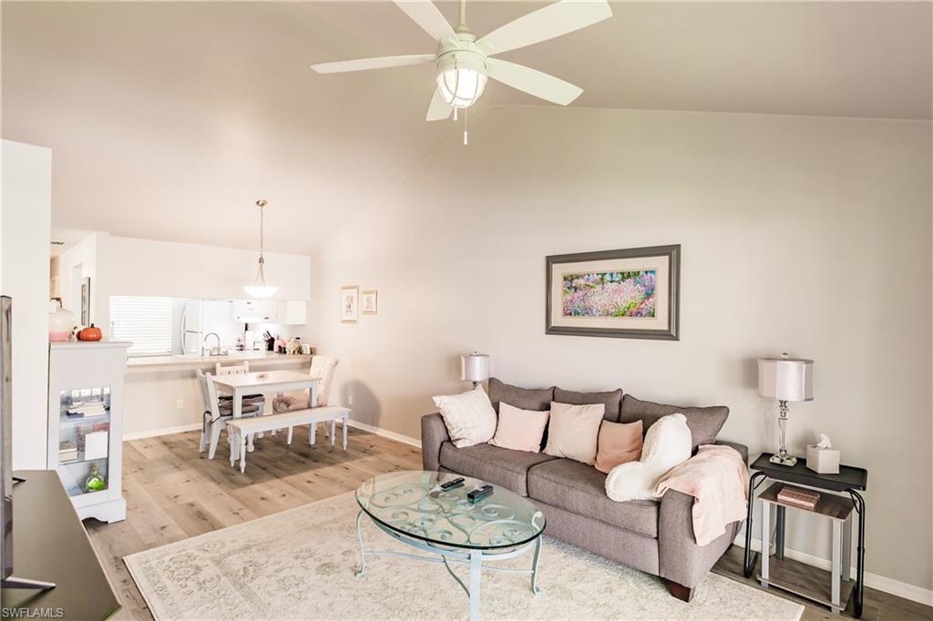 2750 Kings Lake Boulevard, Unit 204 Naples, FL 34112 - Photo 7 of 31 a living room with furniture and a dining table with kitchen view