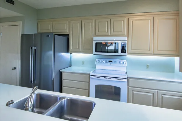 a kitchen with stainless steel appliances granite countertop a refrigerator stove and sink