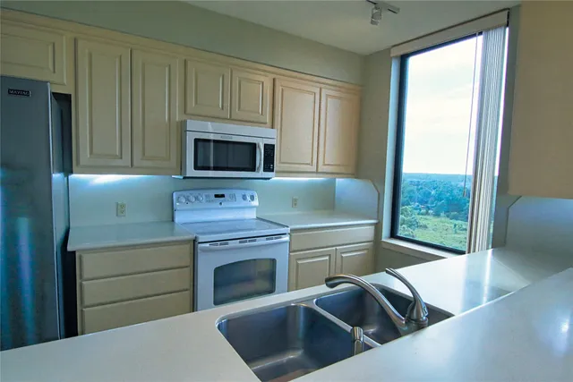 a kitchen with stainless steel appliances granite countertop a stove a sink and a microwave