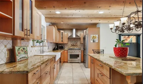 a kitchen with stainless steel appliances granite countertop a sink a stove and a refrigerator