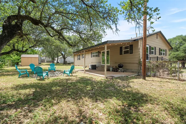 a view of a house with backyard and a tree