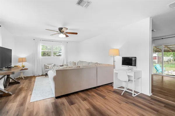 a living room with furniture a flat screen tv and a floor to ceiling window