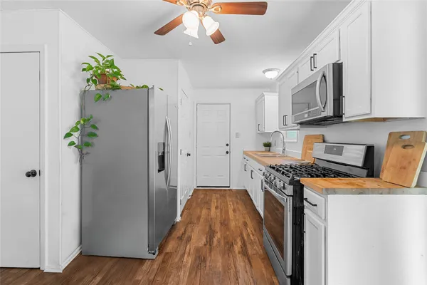 a kitchen with stainless steel appliances granite countertop a refrigerator a stove top oven a sink and dishwasher