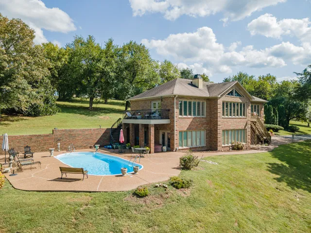 a view of a house with swimming pool and yard