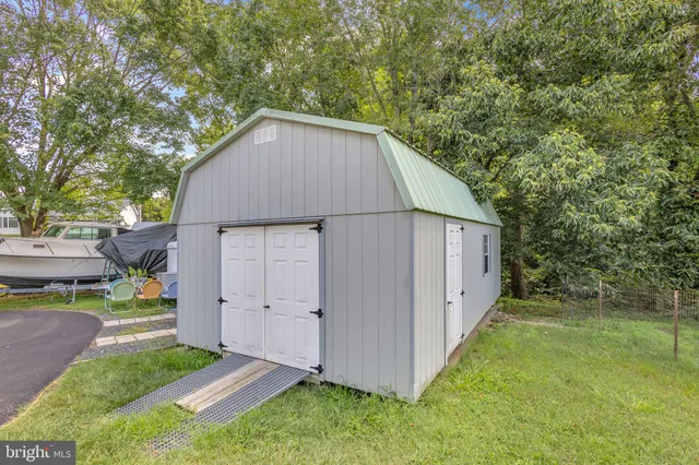 a view of backyard of house with wooden fence and large trees