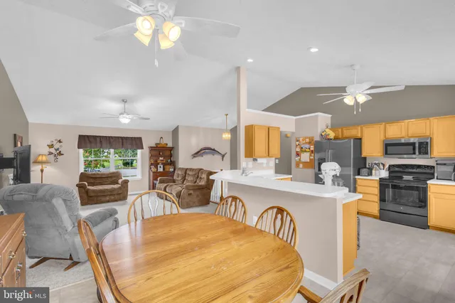 a view of a dining room with furniture a kitchen and chandelier