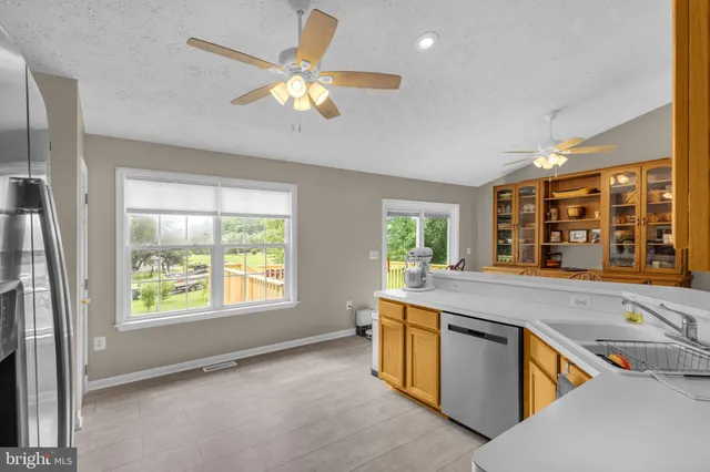 a living room with stainless steel appliances granite countertop furniture and a large window
