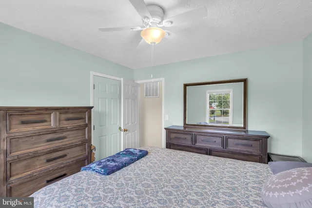 a bedroom with a bed and a chandelier fan