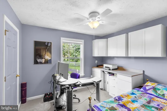 a view of a workspace with furniture and a window