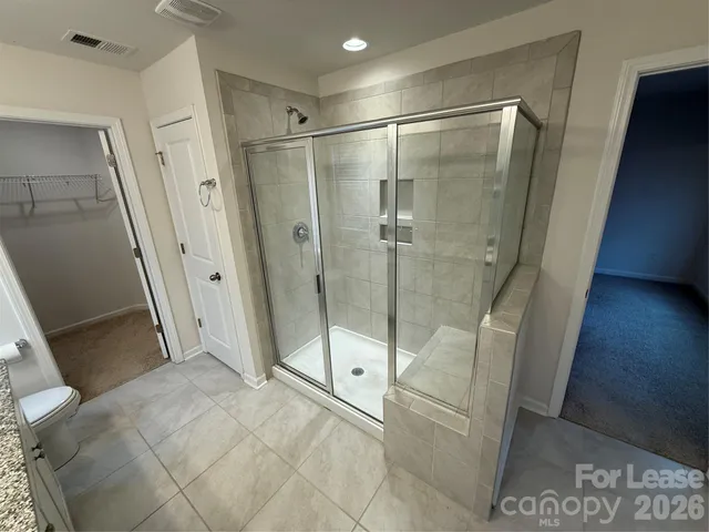 a bathroom with a granite countertop sink a mirror and a shower