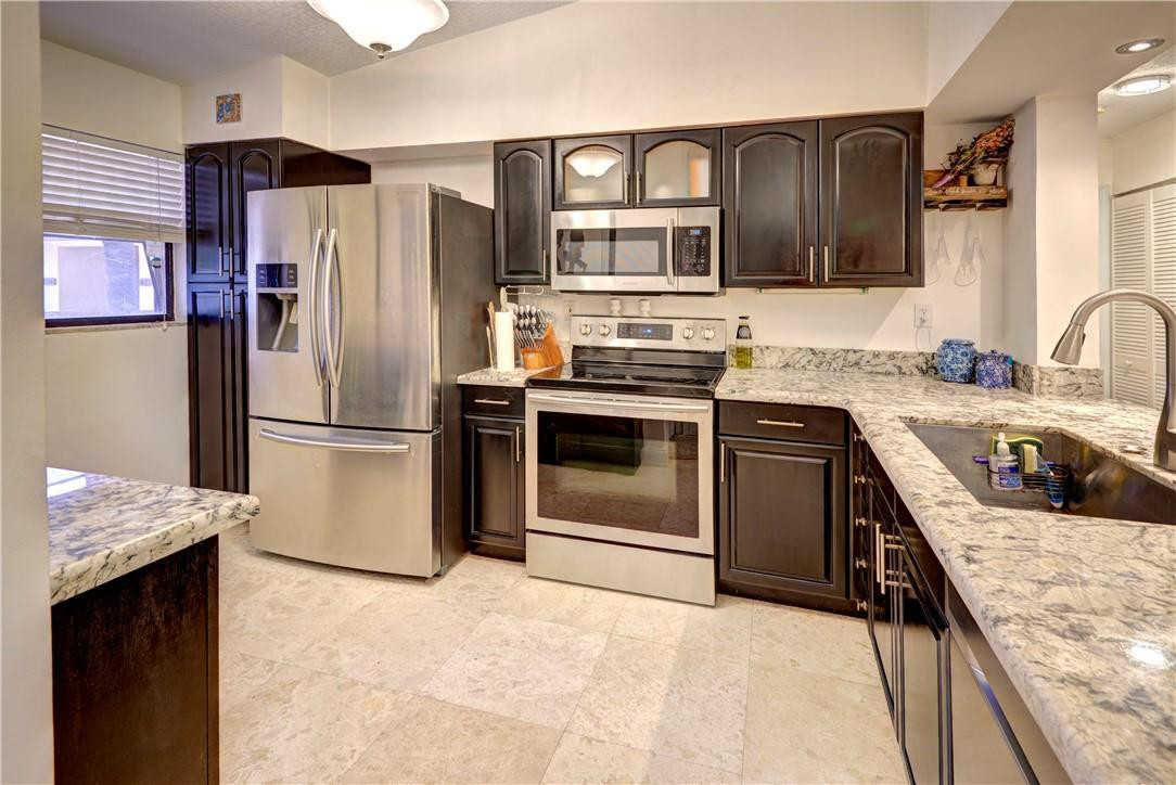 3130 Millwood Terrace, Unit M210 Boca Raton, FL 33431 - Photo 1 of 23 a kitchen with stainless steel appliances granite countertop a refrigerator stove and sink