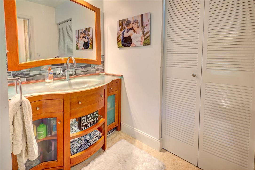3130 Millwood Terrace, Unit M210 Boca Raton, FL 33431 - Photo 17 of 23 a bathroom with a sink and a mirror