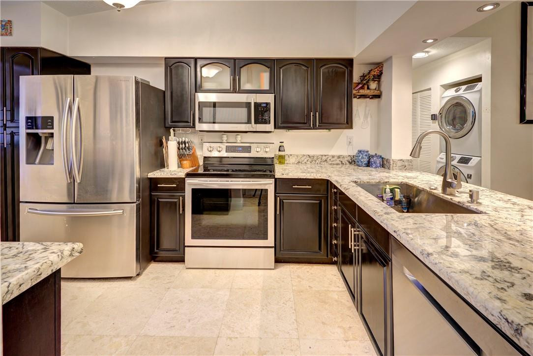 3130 Millwood Terrace, Unit M210 Boca Raton, FL 33431 - Photo 2 of 23 a kitchen with a sink stove and refrigerator