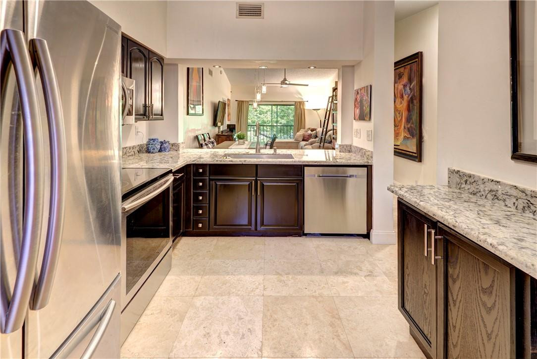 3130 Millwood Terrace, Unit M210 Boca Raton, FL 33431 - Photo 3 of 23 a spacious bathroom with a granite countertop sink a mirror and a bathtub
