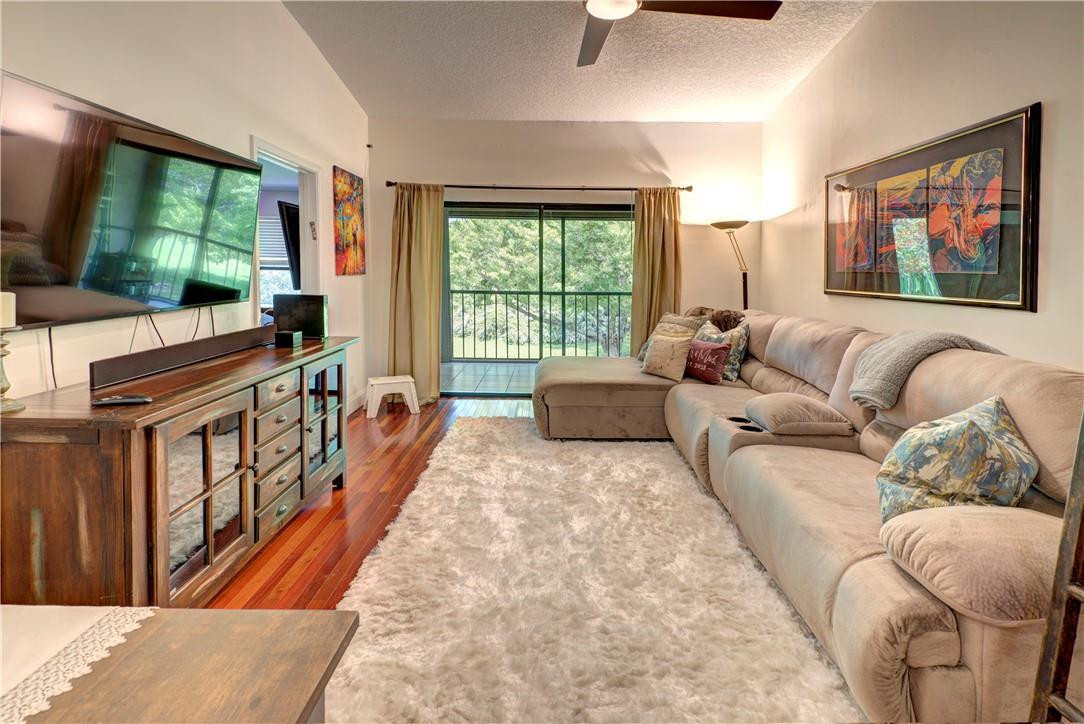 3130 Millwood Terrace, Unit M210 Boca Raton, FL 33431 - Photo 7 of 23 a living room with furniture a flat screen tv next to a large window