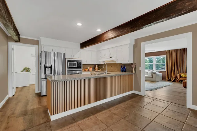 a kitchen with granite countertop a sink stainless steel appliances and cabinets