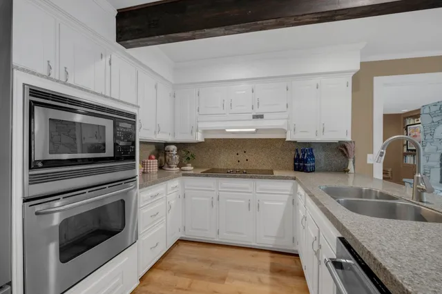 a kitchen with white cabinets and a stove