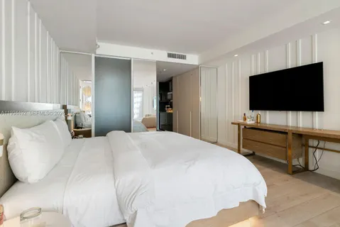 a bedroom with a bed and a flat screen tv