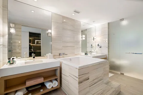 a spacious bathroom with double vanity and a bathtub