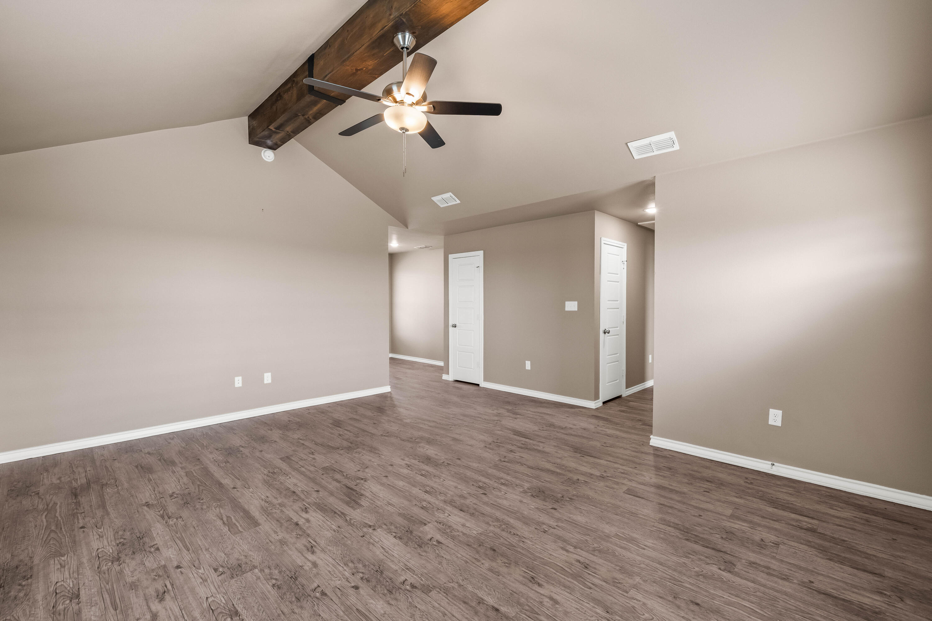 4202 East 64th Street Lubbock, TX 79403 - Photo 3 of 19 an empty room with wooden floor ceiling fan and windows