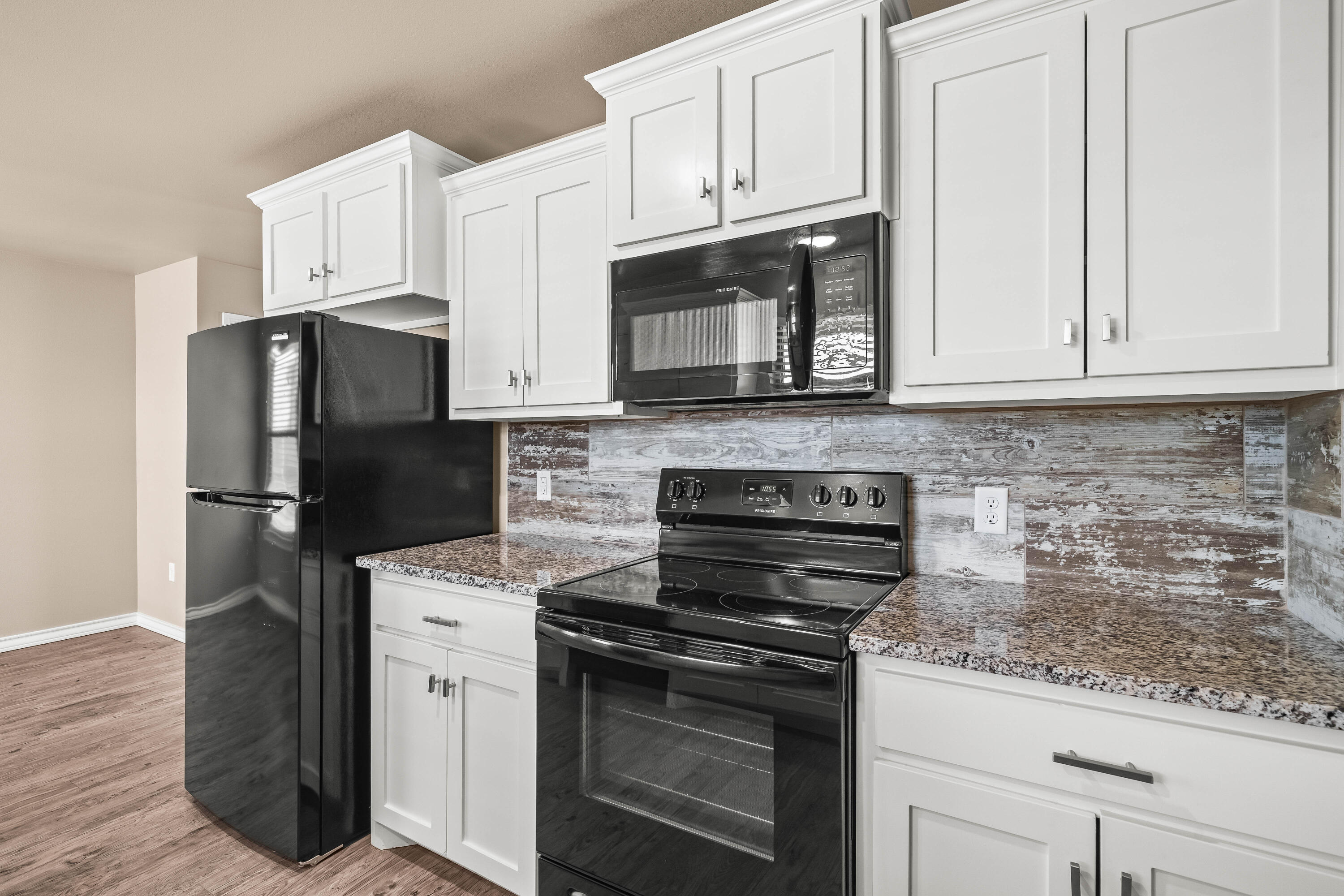 4202 East 64th Street Lubbock, TX 79403 - Photo 9 of 19 a kitchen with stainless steel appliances granite countertop a stove microwave and refrigerator