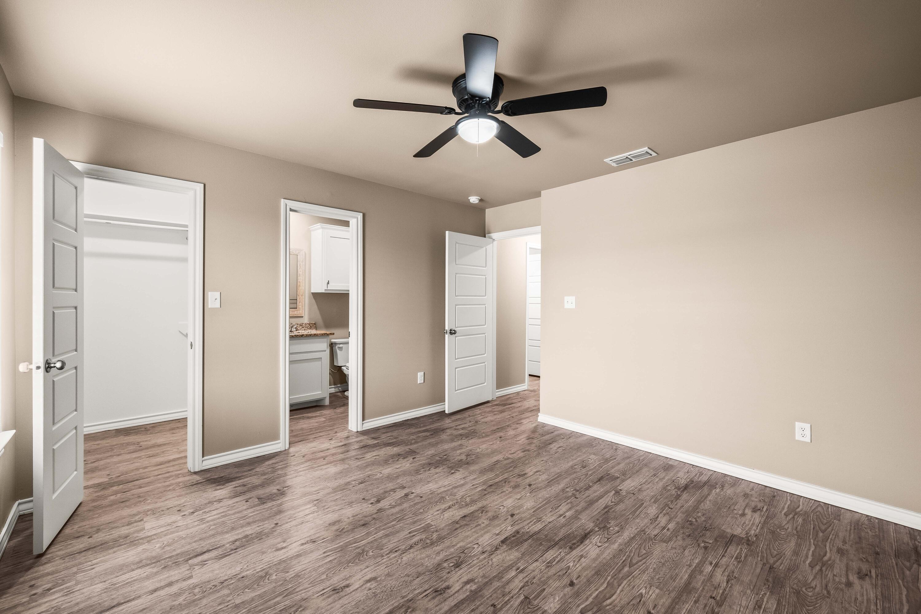 4202 East 64th Street Lubbock, TX 79403 - Photo 10 of 19 a view of a livingroom with wooden floor and a ceiling fan