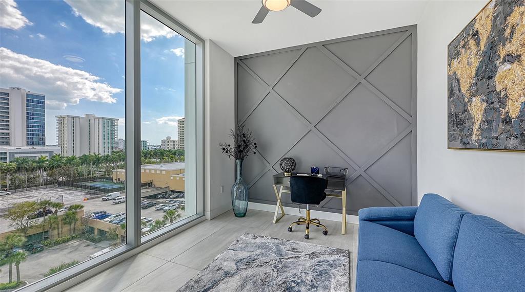 301 Quay Commons, Unit 606 Sarasota, FL 34236 - Photo 16 of 36 a living room with furniture and a floor to ceiling window
