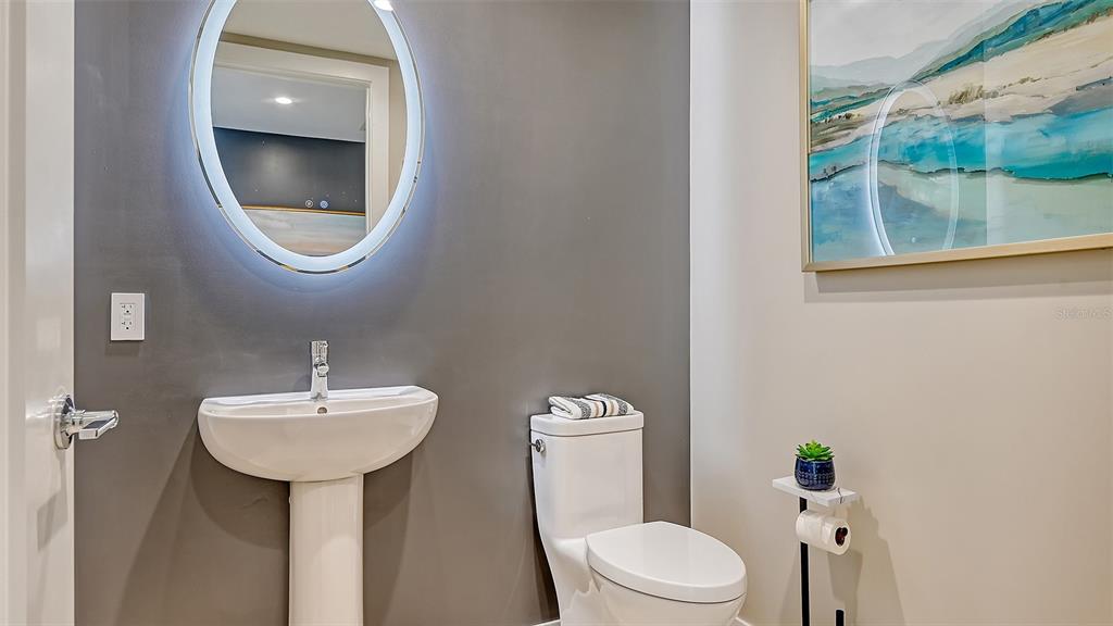 301 Quay Commons, Unit 606 Sarasota, FL 34236 - Photo 19 of 36 a bathroom with a toilet sink and mirror