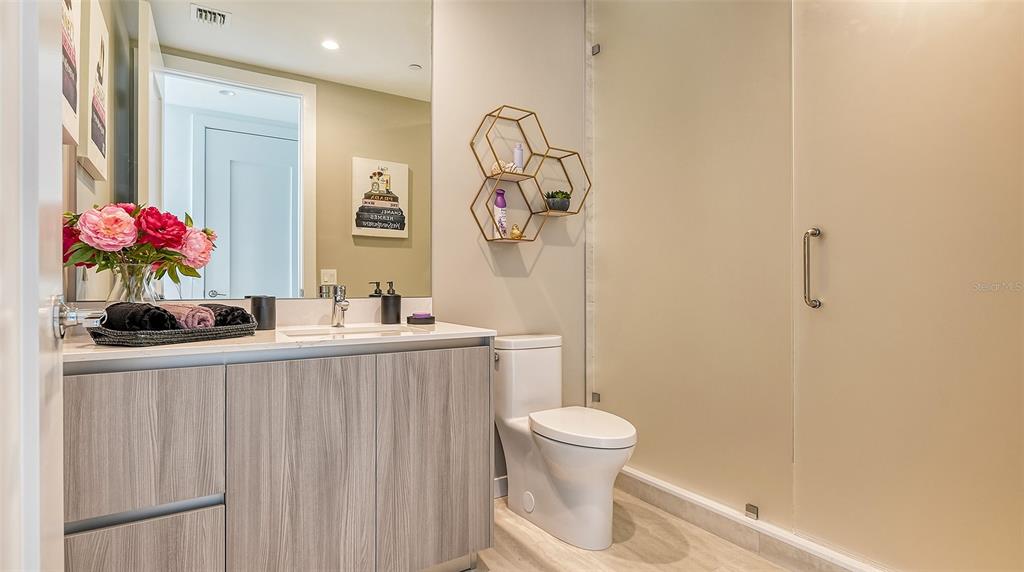 301 Quay Commons, Unit 606 Sarasota, FL 34236 - Photo 22 of 36 a bathroom with a sink a toilet and a mirror