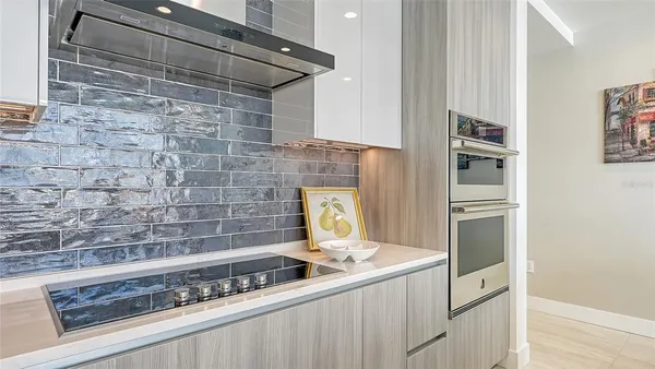 a kitchen with stainless steel appliances granite countertop a dining table and chairs