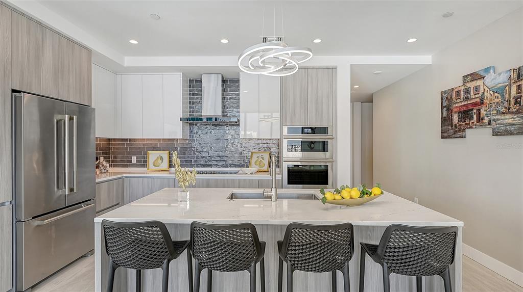 301 Quay Commons, Unit 606 Sarasota, FL 34236 - Photo 7 of 36 a kitchen with stainless steel appliances granite countertop a dining table and chairs